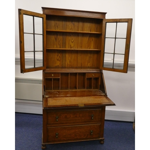 714 - A 1920/30's oak bureau bookcase with panelled glass doors above full front with pigeonholes and draw... 