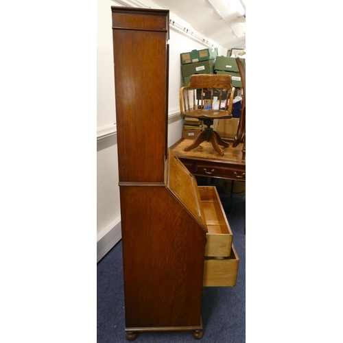 714 - A 1920/30's oak bureau bookcase with panelled glass doors above full front with pigeonholes and draw... 