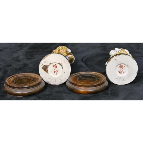 34 - A pair of Oriental figures of gentleman and lady with allover gilt decoration, on round wooden  base... 