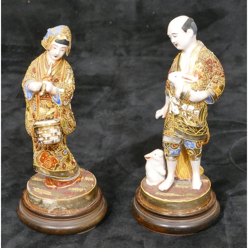 34 - A pair of Oriental figures of gentleman and lady with allover gilt decoration, on round wooden  base... 