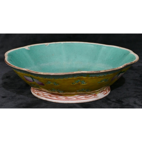 115 - An Oriental glazed round scallop shaped shallow bowl on yellow and green ground with fruit and scrol... 