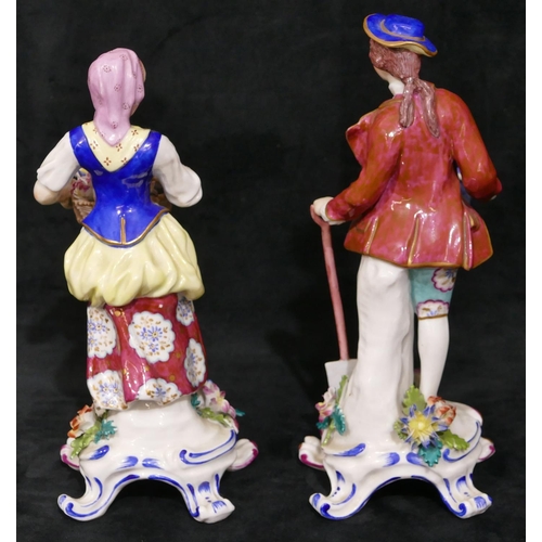 121 - A pair of Continental porcelain figures of gentleman and lady holding encrusted flowers and fruit wi... 