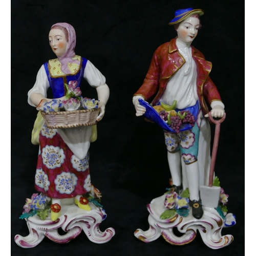 121 - A pair of Continental porcelain figures of gentleman and lady holding encrusted flowers and fruit wi... 