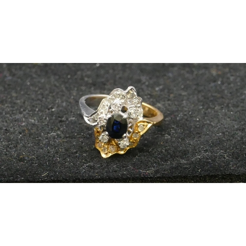 499 - A high ct gold 2-coloured gold cluster ring set with centre sapphire and surrounded by graduated dia... 