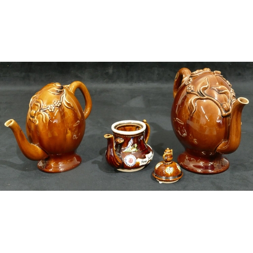 151 - 2 Treacle ware puzzle teapots with raised floral and leaf decoration, largest 20.5cm high (smallest ... 