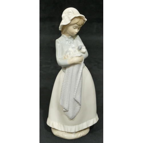 163 - A Nao figure of a standing young lady holding a puppy, 25cm high