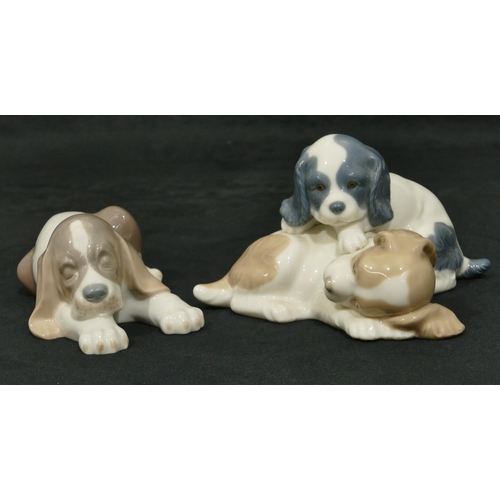 167 - A Lladro figure of a puppy on white and brown ground, 17cm wide, a Nao group of 2 puppies (2)