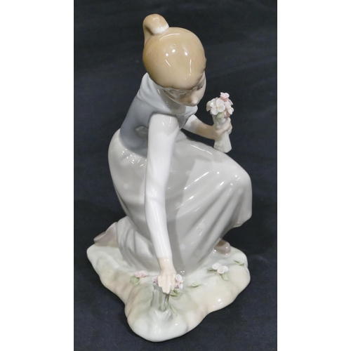 24 - A Lladro figure of a kneeling young girl holding encrusted flowers, 20cm high