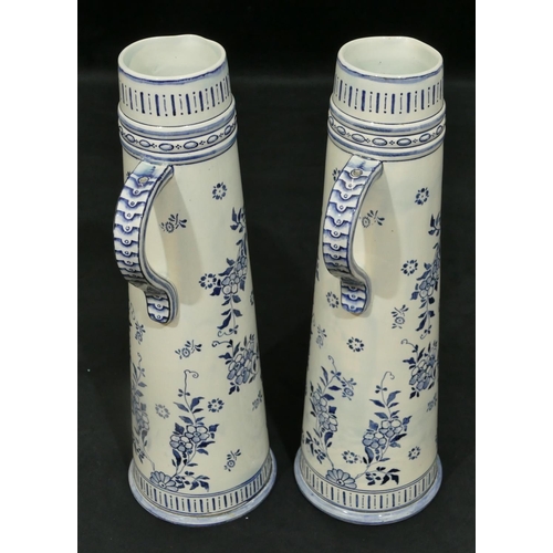 45 - A pair of 20th Century blue and white Delft tall jugs depicting windmill, floral and scroll decorati... 