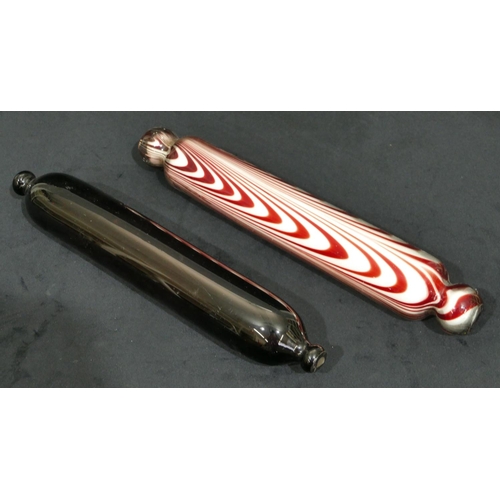 66 - A clear and ruby glass rolling pin, 37cm long, a 19th Century brown glass rolling pin, 35cm long (2)