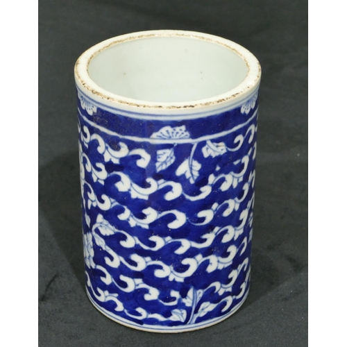 69 - An Oriental cylindrical brush pot on blue and white ground with figure, scroll and leaf decoration, ... 