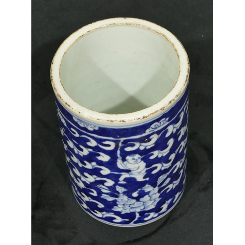 69 - An Oriental cylindrical brush pot on blue and white ground with figure, scroll and leaf decoration, ... 