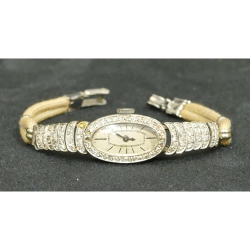 691 - A Longines platinum and diamond ladies cocktail watch with oval dial surrounded by diamonds (2 missi... 