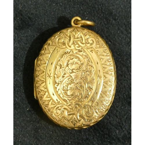 693 - A 15ct gold oval locket with hinged front, embossed floral, leaf and scroll decoration, 4cm high wit... 