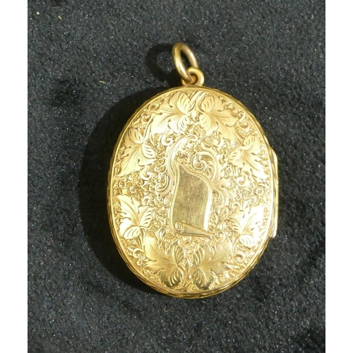 693 - A 15ct gold oval locket with hinged front, embossed floral, leaf and scroll decoration, 4cm high wit... 