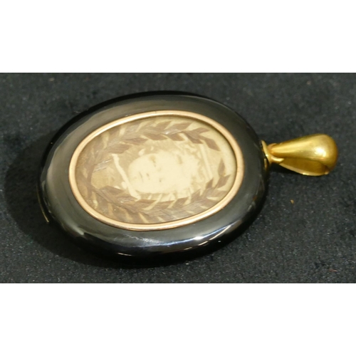 694 - A 15ct gold and onyx oval memorial pendant mounted with single pearl, 5.5cm high overall