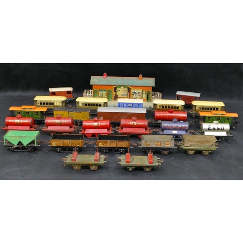 703 - 25 Hornby O-gauge carriages and trucks (no engines) and a similar station. (26)