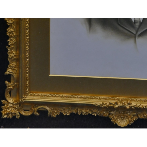 706 - An opaline shoulder length portrait of a gentleman in fine gilt frame with raised floral and leaf de... 