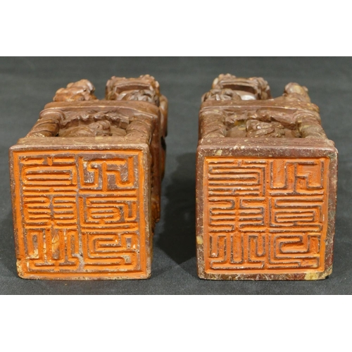 712 - A pair of Oriental hardstone large seals depicting dogs of fo standing upon square plinths with rais... 