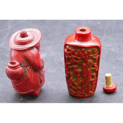 729 - An Oriental red snuff bottle with stopper, raised figure decoration 7cm high, a similar snuff bottle... 