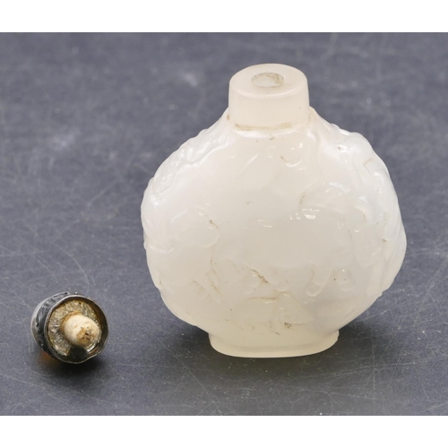 731 - An Oriental hardstone round bulbous shaped bottle with raised figure and scroll decoration with stop... 