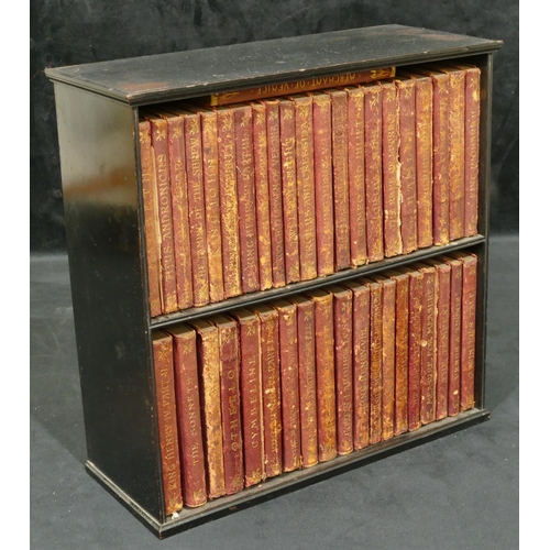 738 - A collection of red leather bound Shakespeare books, all mounted in ebonised table top cabinet