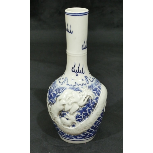 74 - An Oriental round bulbous thin necked vase on blue and white ground with raised dragon decoration, 2... 