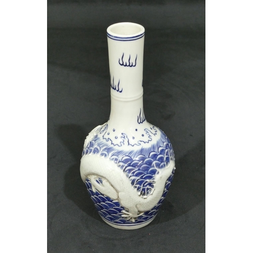 74 - An Oriental round bulbous thin necked vase on blue and white ground with raised dragon decoration, 2... 