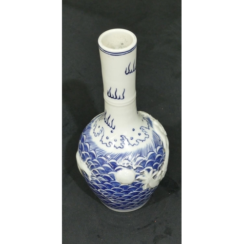 74 - An Oriental round bulbous thin necked vase on blue and white ground with raised dragon decoration, 2... 