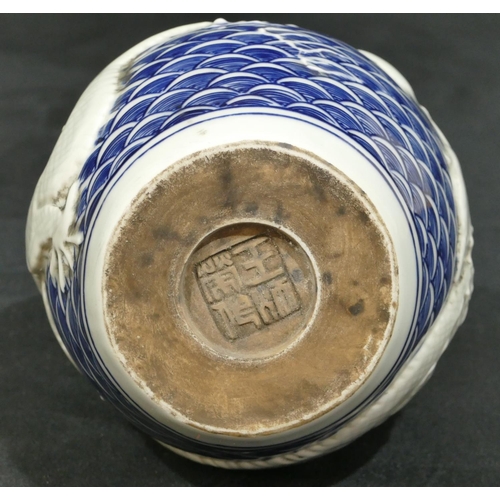 74 - An Oriental round bulbous thin necked vase on blue and white ground with raised dragon decoration, 2... 