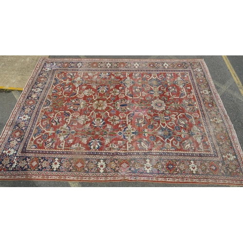 755 - A Persian carpet of red ground with allover decoration (worn), 355cm x 275cm.