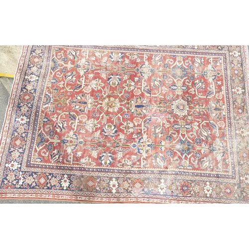 755 - A Persian carpet of red ground with allover decoration (worn), 355cm x 275cm.