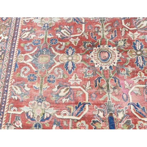 755 - A Persian carpet of red ground with allover decoration (worn), 355cm x 275cm.