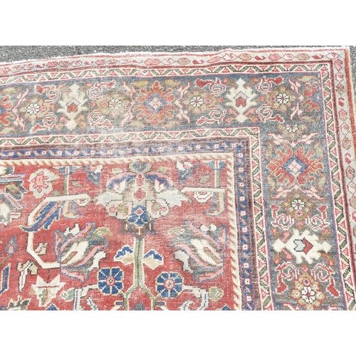 755 - A Persian carpet of red ground with allover decoration (worn), 355cm x 275cm.