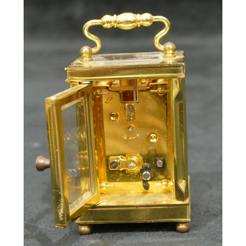 811 - Lionel Peck, London miniature brass carriage clock with white enamel dial, Roman numerals, swing ove... 