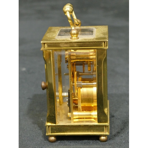 811 - Lionel Peck, London miniature brass carriage clock with white enamel dial, Roman numerals, swing ove... 