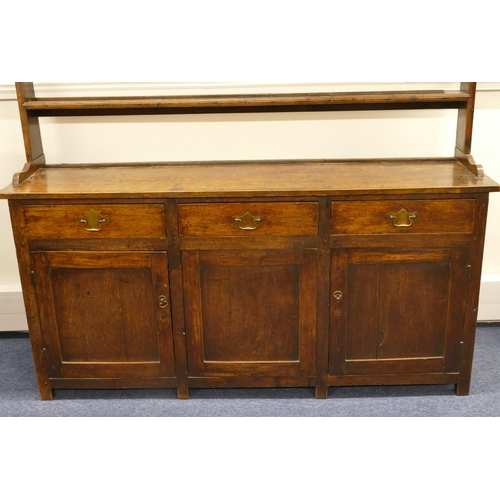 835 - A Georgian oak Welsh dresser with open shelf back, 3 drawers above single panel, flanked by 2 panel ... 