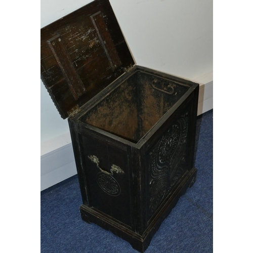 820 - A carved oak coal box with hinged lid with floral and leaf decoration, enclosing liner on bracket fe... 