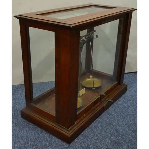 4114 - A set of brass balance scales in fitted mahogany cabinet, 48cm wide, 42cm high.