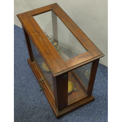 4114 - A set of brass balance scales in fitted mahogany cabinet, 48cm wide, 42cm high.