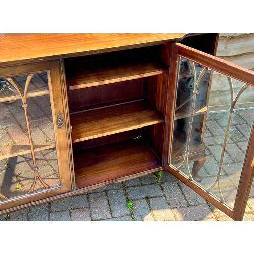 4146 - A mahogany breakfront low display cabinet, 2 glass panelled doors enclosing shelves, flanked by open... 