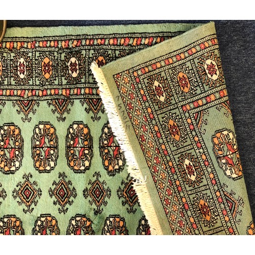 5002 - A modern Bokara rug on green ground with 11 x 2 centre medallions, 151cm x 94
