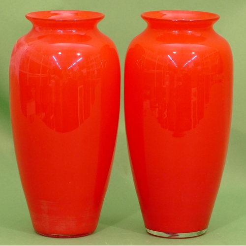 62 - A pair of red glass round bulbous thin necked trumpet shaped vases, 27cm high.