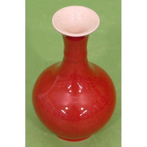 69 - An Oriental small round bulbous thin necked trumpet shaped vase on red ground, 15cm high.