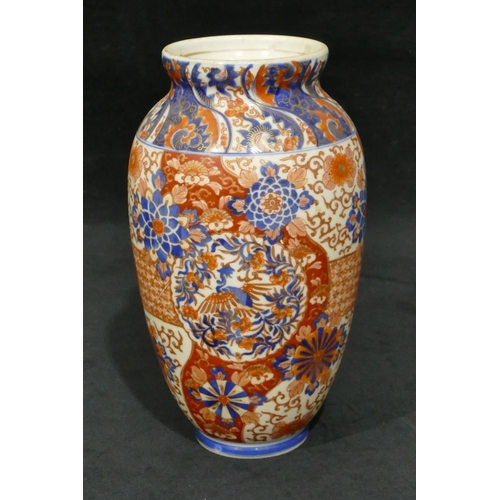 103 - An Imari round bulbous thin necked vase on white, red and blue ground with allover floral, leaf and ... 