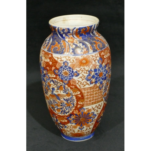 103 - An Imari round bulbous thin necked vase on white, red and blue ground with allover floral, leaf and ... 