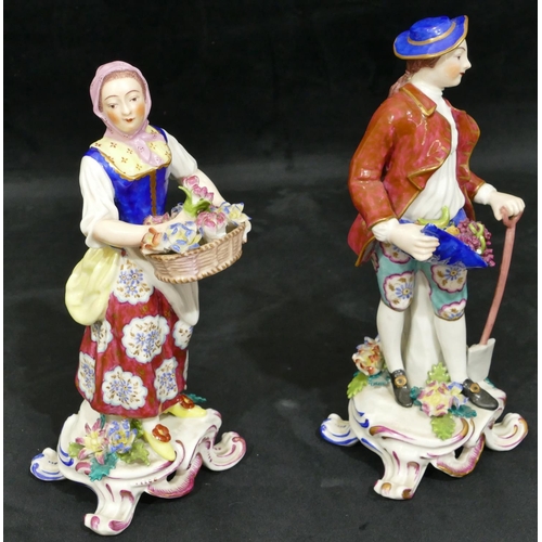 18 - A pair of Continental china figures of gentleman and lady holding encrusted flowers and fruit with s... 