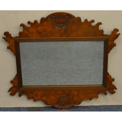 628 - A small burr walnut hanging wall mirror with scallop shaped rim and carved shell motif, 52cm wide, 4... 