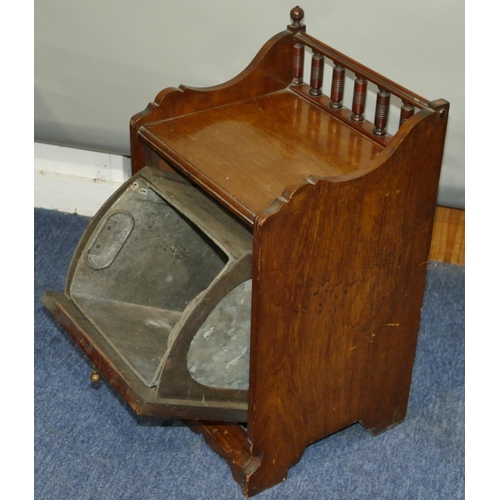 633 - A mahogany coal scuttle with spindle back, panelled drop front enclosing liner, 34cm wide, 60cm high... 