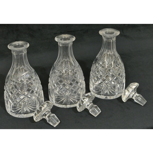 67 - A set of 3 cut glass round bulbous thin necked decanters with mushroom shaped stoppers, 26.5cm high.